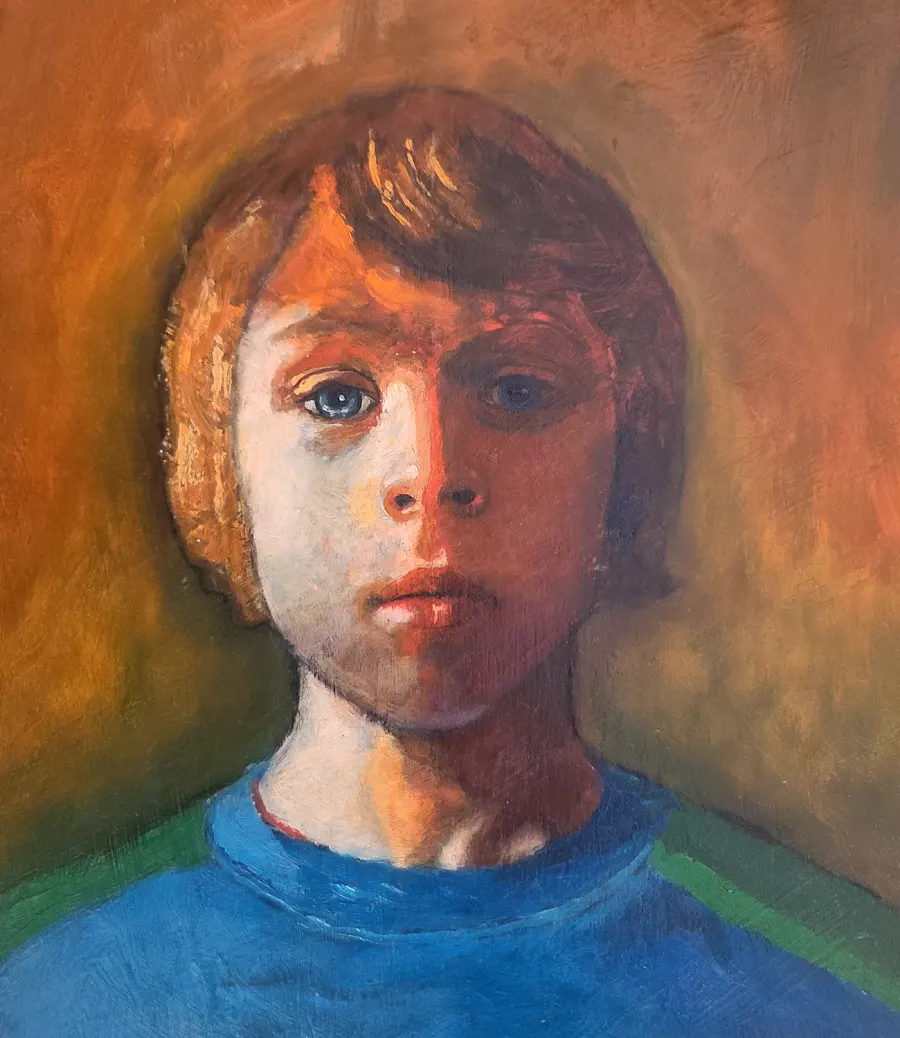Portrait of a boy in a blue shirt against a warm orange background